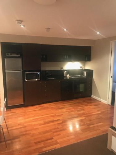 a kitchen with black appliances and a wooden floor at Museum Apartment in Wellington