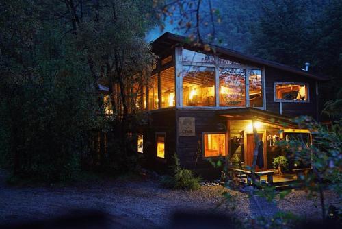 a house with lights in the windows at night at Onai Hostel in Las Trancas