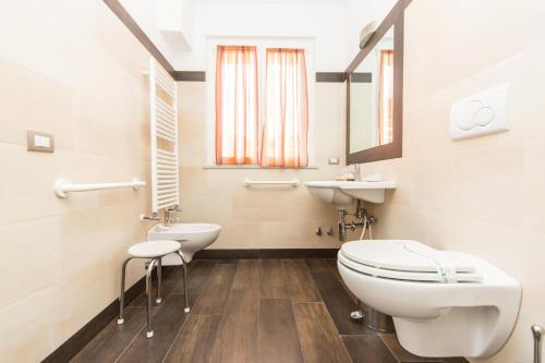 a bathroom with a toilet and a sink at Oasi Hotel in Levanto