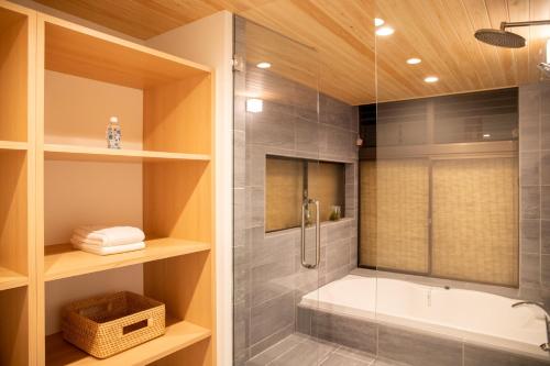 a bathroom with a shower and a bath tub at 貸切宿 茶心 in Shintomi