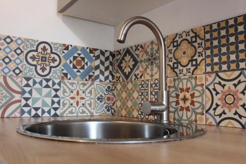 un fregadero de acero inoxidable en una cocina con azulejos en L'Éphémère Canebière - Gambetta, en Marsella