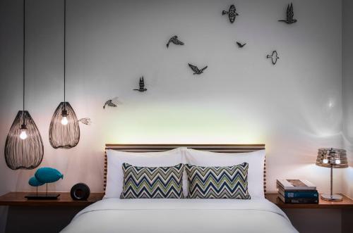a bedroom with a bed with two lamps and two tables at The Aviary Hotel in Siem Reap