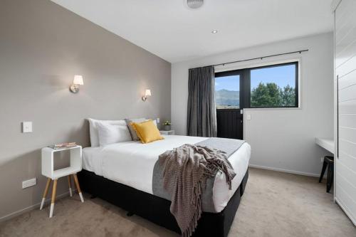 a bedroom with a large bed and a window at Maunga View in Queenstown