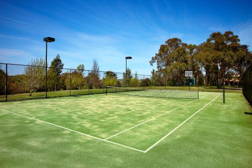 a tennis court with a net in a park at Lawson Lodge Country Estate in Macedon