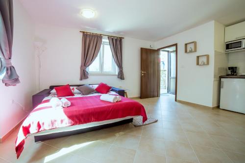 a bedroom with a large bed with a red blanket at Apartment Podini in Brseč
