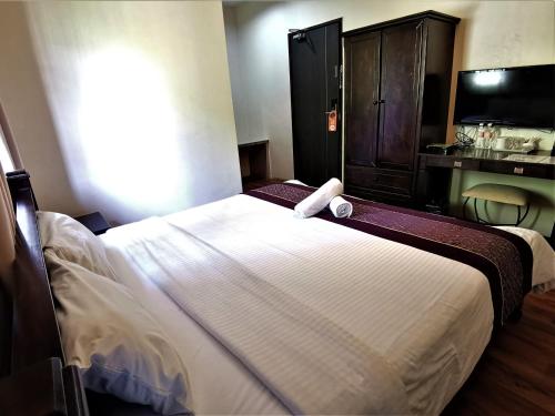 a bedroom with a large white bed with a television at 8 Boutique By The Sea in George Town