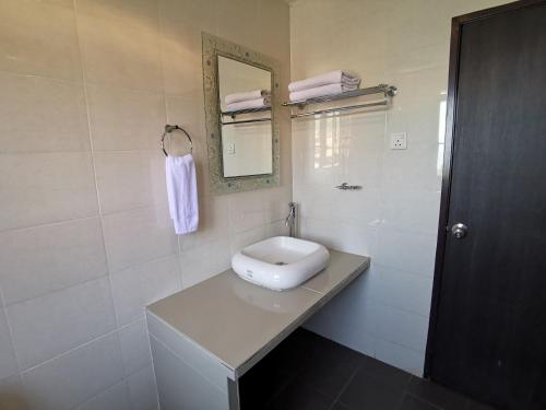 a white bathroom with a sink and a mirror at 8 Boutique By The Sea in George Town