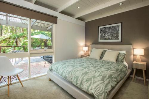 a bedroom with a bed and a large window at Fernview on Falls in Kalorama