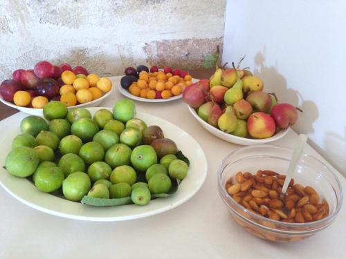 a table topped with plates of fruit and bowls of nuts at Masseria Carignani in Tuglie