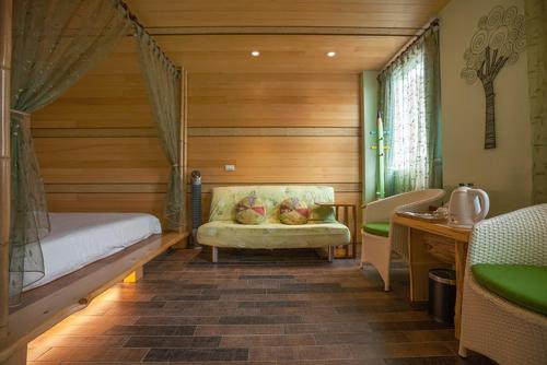 a bedroom with a bed and a couch and a sink at Tobe Home in Luodong