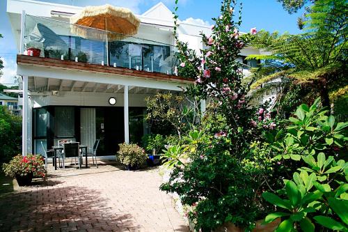 a house with a porch and a balcony with flowers at Corlette Retreat in Corlette