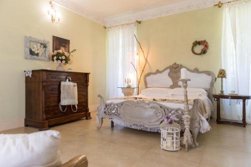 a bedroom with a white bed and a wooden dresser at filobrocante in Torre Santa Susanna
