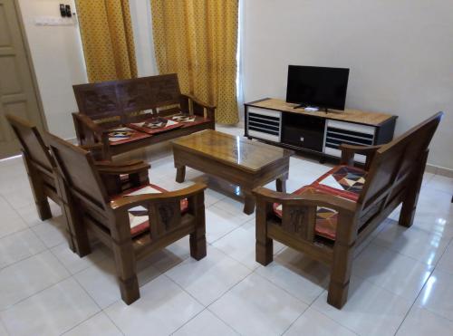 a living room with a table and chairs and a television at Muslim 2 Stay in Melaka