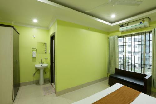a bathroom with a bed and a sink and a toilet at Hotel Grand Luit in Guwahati