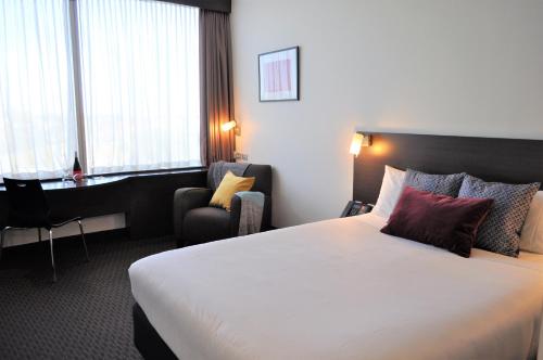 a hotel room with a bed and a desk at ibis Melbourne - Glen Waverley in Glen Waverley
