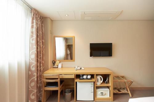 a hotel room with a desk and a mirror at Towerhill Hotel in Busan