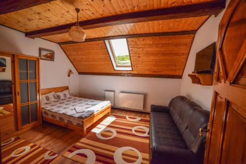 a bedroom with a bed and a couch in a room at Pensiunea Montana Muntele Mic in Muntele Mic