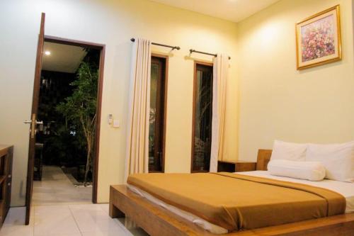 Un dormitorio con una cama y una puerta corrediza de vidrio. en Putri Homestay, en Sanur