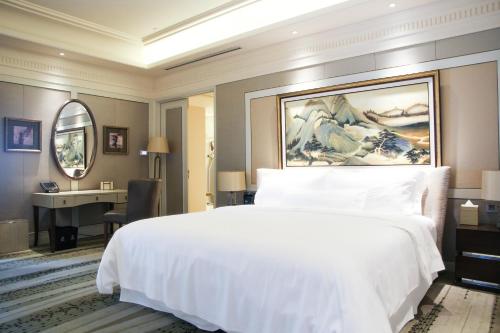 a bedroom with a large white bed and a desk at The Westin Qingdao - Instagrammable in Qingdao