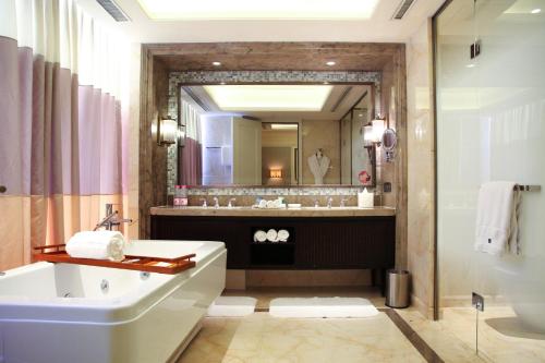 a bathroom with a tub and a sink and a mirror at The Westin Qingdao - Instagrammable in Qingdao