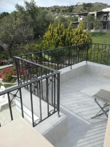 a patio with a black railing and some chairs at Hotel Dimitra Sun in Archangelos