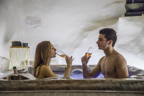 un hombre y una mujer bebiendo vino en una bañera en Monaco's Cottage & Spa, en Roquebrune-Cap-Martin
