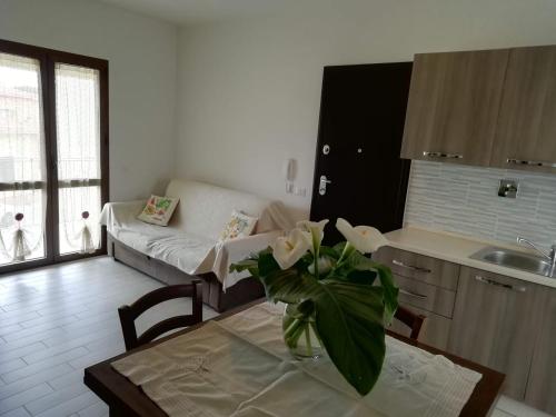 cocina y sala de estar con mesa y sofá en B&B Nino, en Olbia