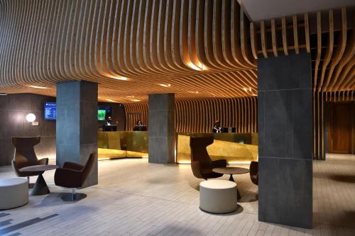 a lobby with chairs and tables in a building at Pullman Abidjan in Abidjan