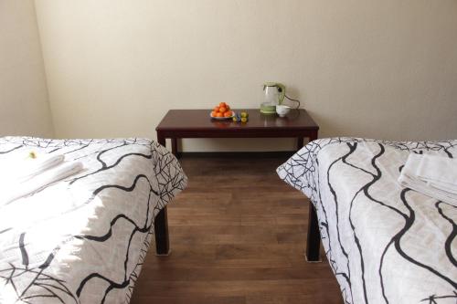 a room with two beds and a table with oranges on it at Snow Leopard Hostel in Karakol