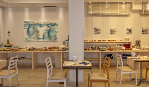 a restaurant with tables and chairs in a room at Hotel Central Park in Marina di Pietrasanta