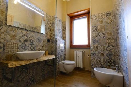bagno con 2 lavandini, servizi igienici e specchio di Florence Fevira Airport a Firenze