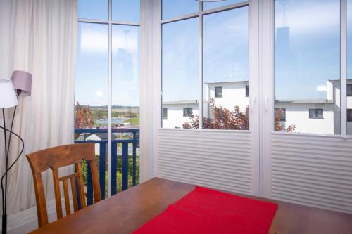 オストゼーバート・ゼリンにあるFerienwohnung Deichblickの窓(テーブル付)と赤い敷物が備わる客室です。