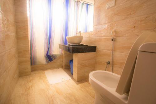 La petite salle de bains est pourvue d'un lavabo et de toilettes. dans l'établissement Prime Park Hotel, à Cox's Bazar