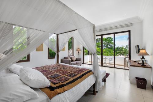 a bedroom with a bed with a canopy at Villa Pantai Karang in Sanur