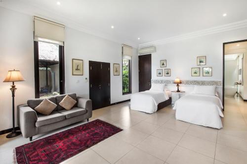 a living room with two beds and a couch at Villa Pantai Karang in Sanur