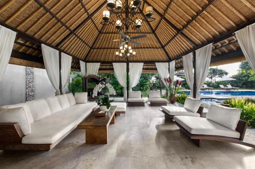 a living room with white couches and a chandelier at Villa Pantai Karang in Sanur