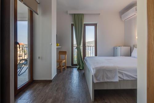 a bedroom with a bed and a balcony at Mima Apartments in Sveti Stefan