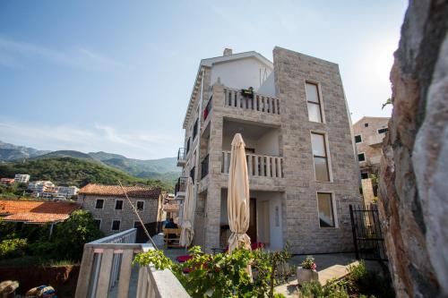 a building with a umbrella on the balcony at Mima Apartments in Sveti Stefan