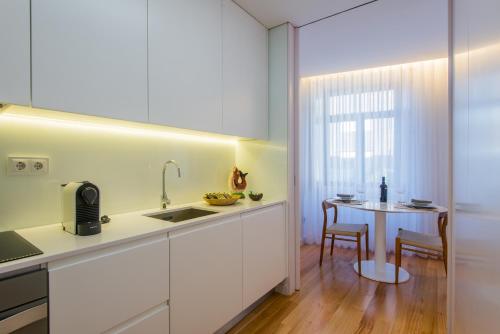 a kitchen with a white counter top and white cabinets at Domum in Porto