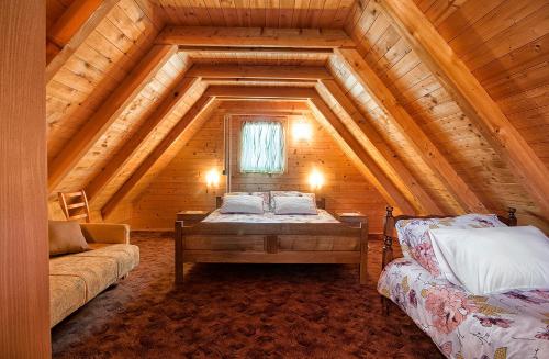 - une chambre avec un lit dans un grenier en bois dans l'établissement Apartment Perić, à Rastovača
