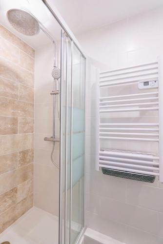 une douche avec une porte vitrée dans une salle de bain dans l'établissement Appart 6 pers vue mer-piscine-parking-clim-wifi, au Cap d'Agde