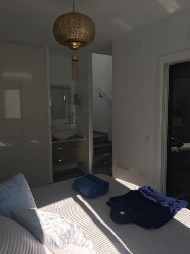 a bedroom with a bed and a bathroom with a sink at Stadthaus Petronella Meerblick und Dachterrasse in Conil de la Frontera