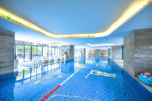a large swimming pool in a building at Sanya Conifer Resort in Sanya