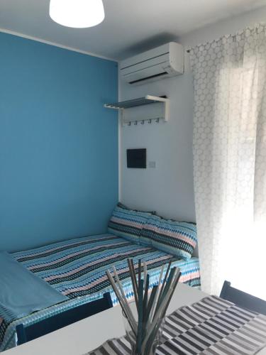 um pequeno quarto com uma cama e uma mesa em Little house em Mazara del Vallo