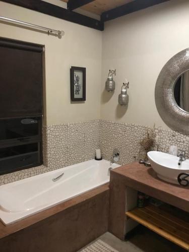 a bathroom with a bath tub and a sink at Twenty Four Mabalingwe Nature Reserve in Warmbaths