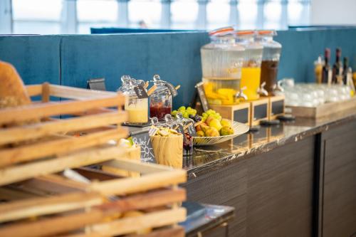 a buffet line with a plate of fruit and drinks at Strandhotel Ahlbeck in Ahlbeck