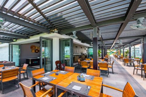 岘港Emblem Sea 4 Bedroom Villas的一间房间里有木桌椅的餐厅