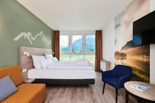 een hotelkamer met een bed en een bank bij aja Ruhpolding in Ruhpolding