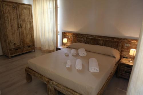Un dormitorio con una cama con zapatillas blancas. en Abas Ristorante Pizzeria Affittacamere, en Ales