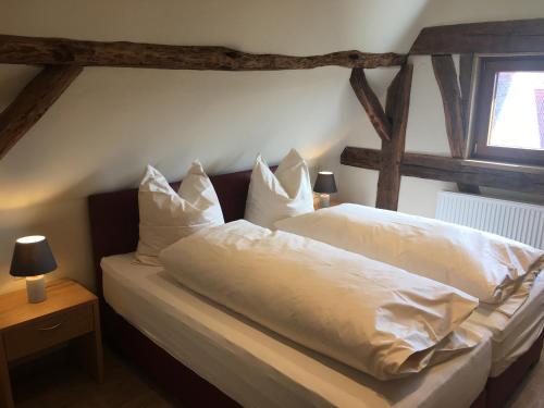 a bedroom with a bed with white sheets and pillows at Gasthof zum Ochsen in Mössingen